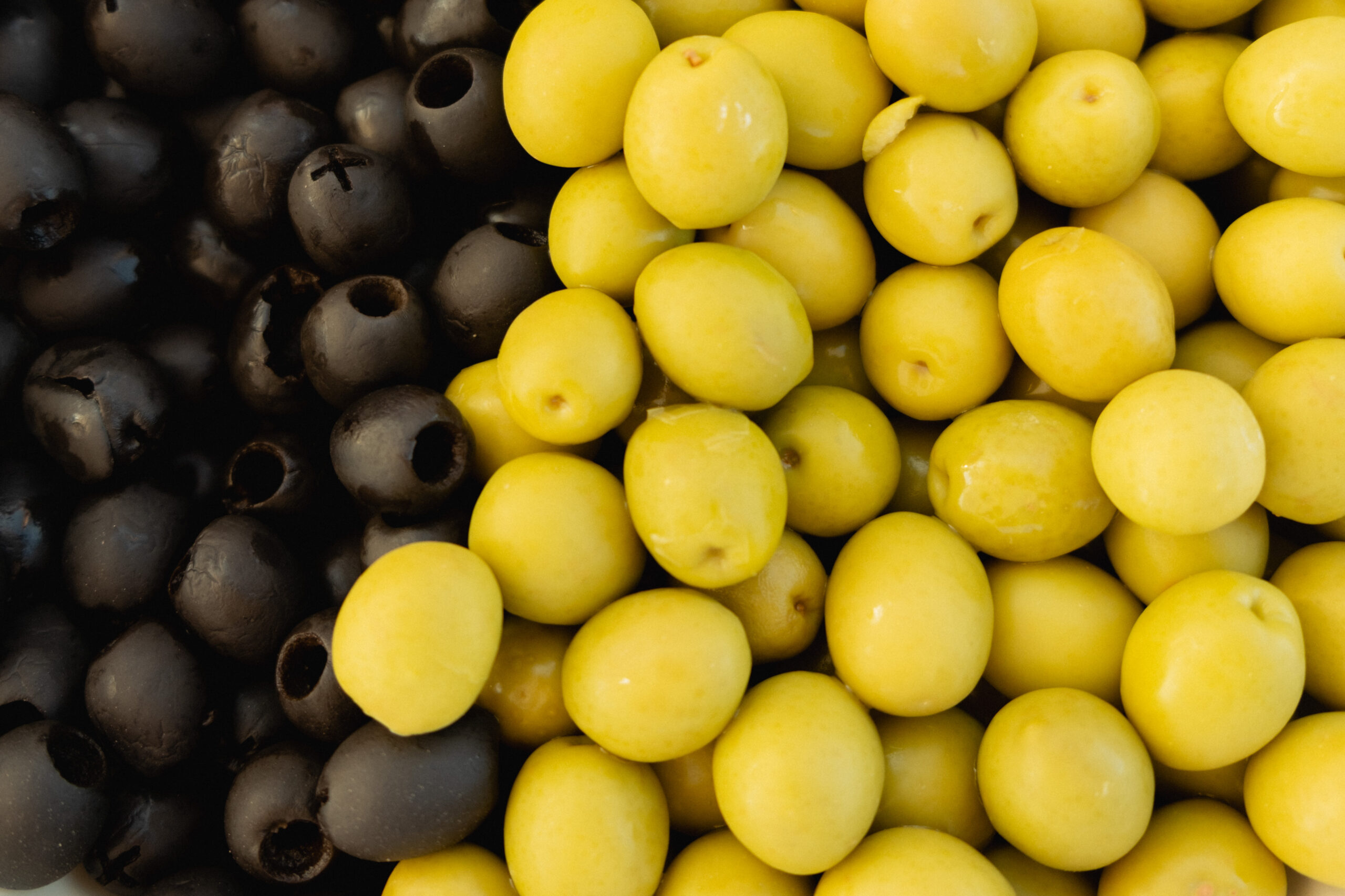close up photograph of green and black olives. colourful edit